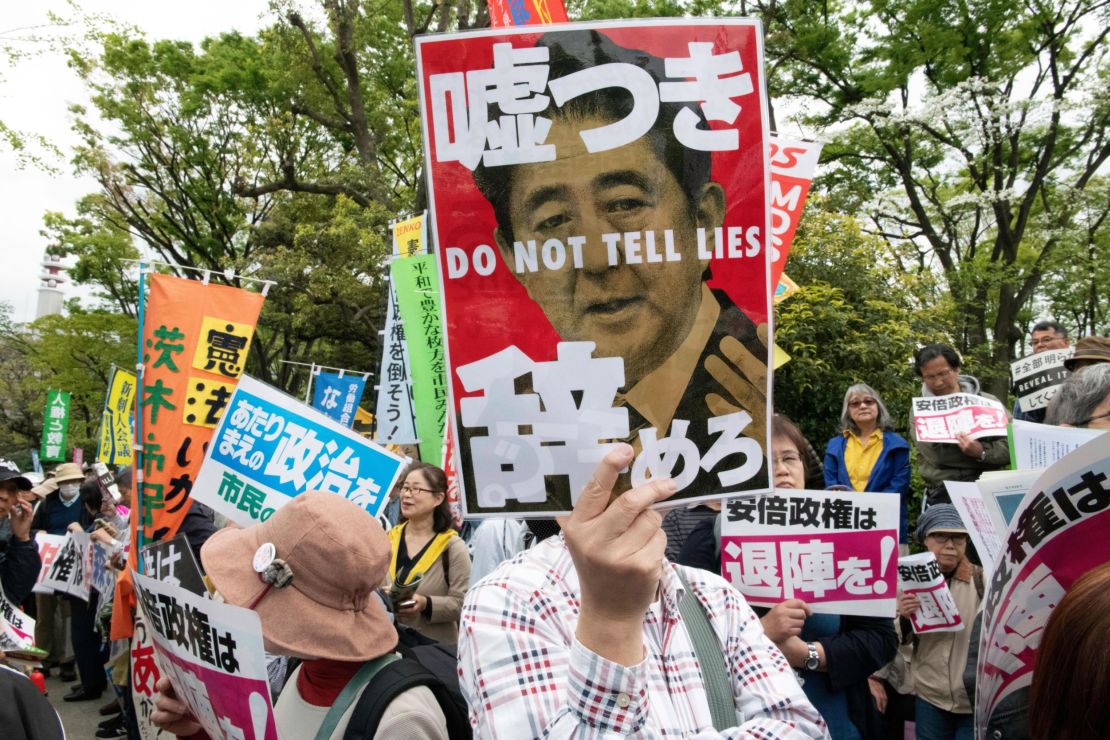 A protester holds a placard during a demonstration against Japan's Prime Minister Shinzo Abe on April 14, 2018.