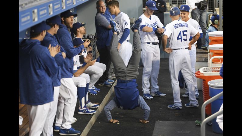 Will Ireton, the interpreter for Dodger pitcher Kenta Maeda, performs a handstand in the dugout before a baseball game against the Oakland Athletics on Wednesday, April 11, in Los Angeles.