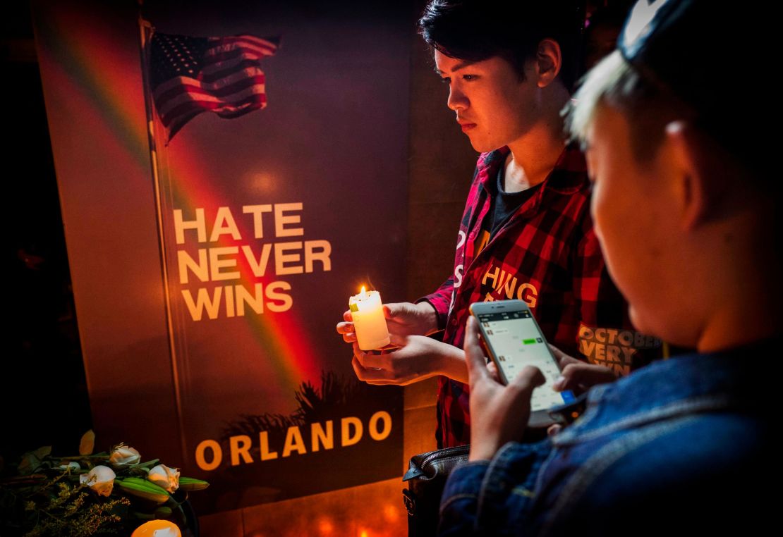  A Chinese man lights a candle at a memorial vigil for the victims of the mass shooting at the Pulse nightclub, at Adam's Bar on June 14, 2016 in Beijing, China. 