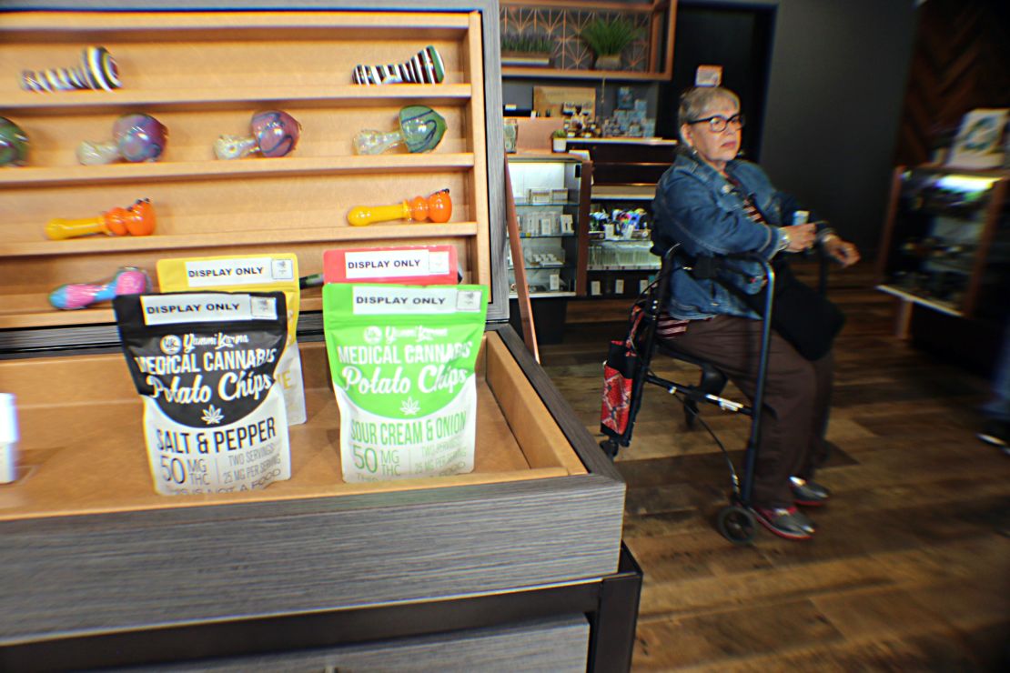 One woman waits to check out by a display of medical cannabis potato chips.