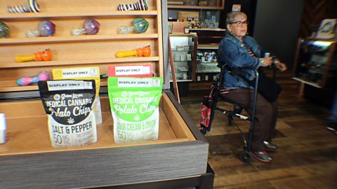 One woman waits to check out by a display of medical cannabis potato chips.