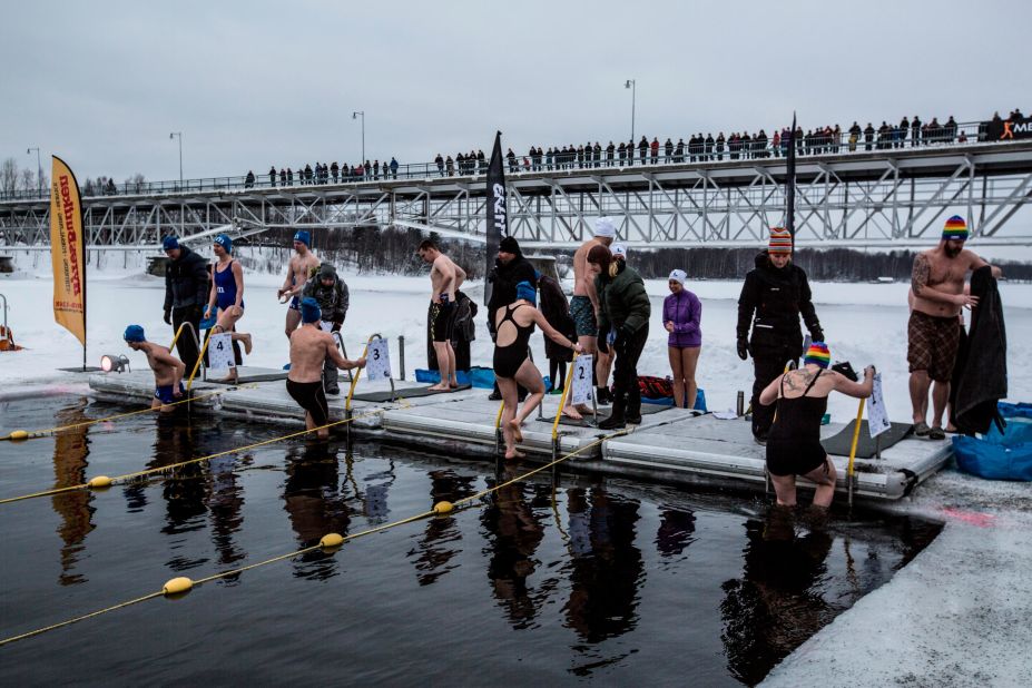 Swimmers descend into the chilly water, as diving is not allowed. Nearly 400 people from 16 countries competed this year.