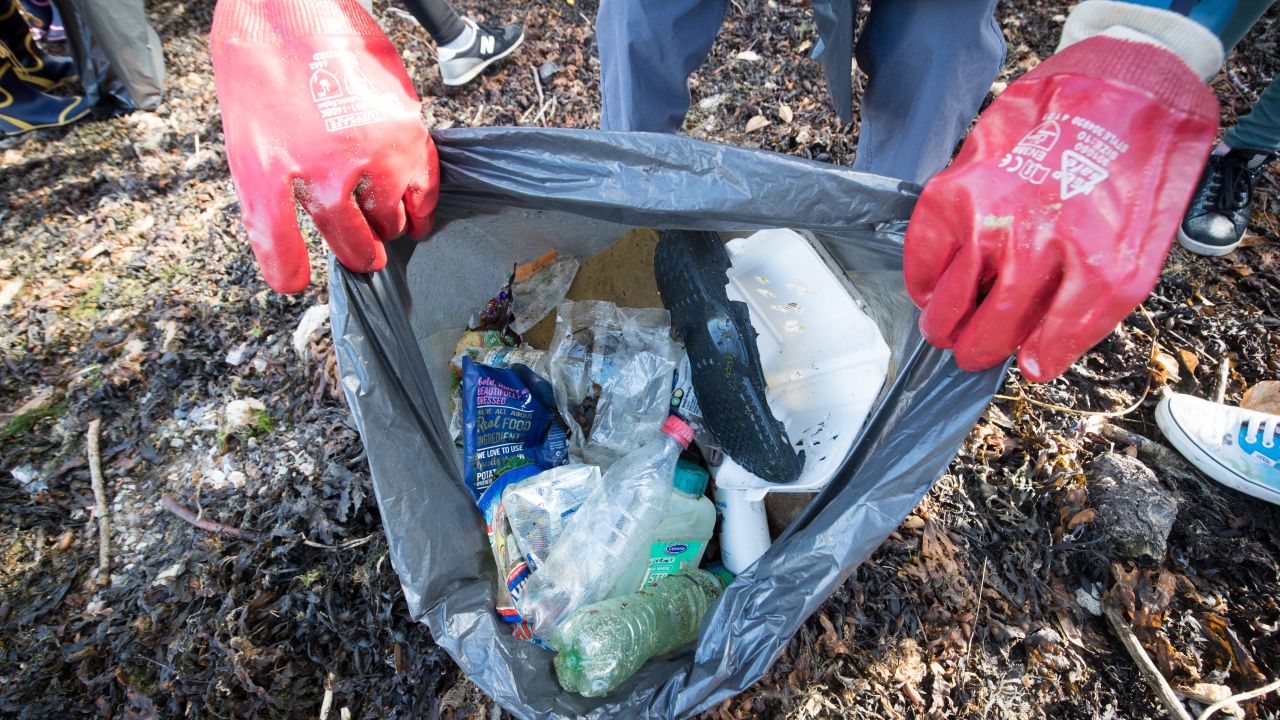 Volunteers collect plastic waste washed up on a beach in Plymouth, southwest England, in August.