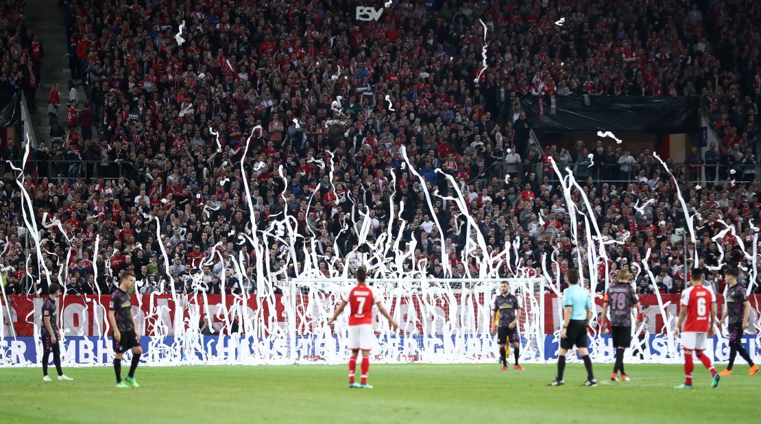 Mainz fans throw rolls of toilet paper onto the pitch to protest Monday night kickoffs.