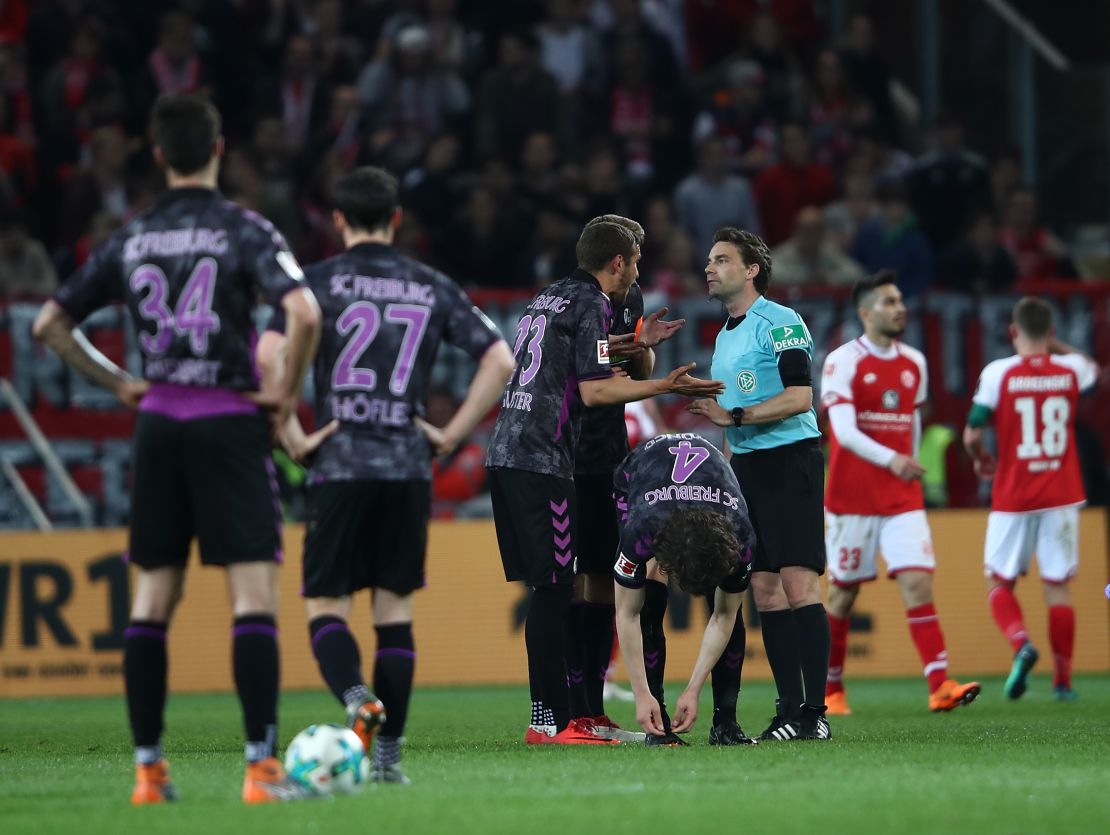 Freiburg players protest to referee Guido Winkmann after the controversial penalty decision.