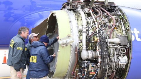 National Transportation Safety Board investigators inspect a Southwest Airlines plane after engine failure caused the flight to make an emergency landing at Philadelphia International Airport.