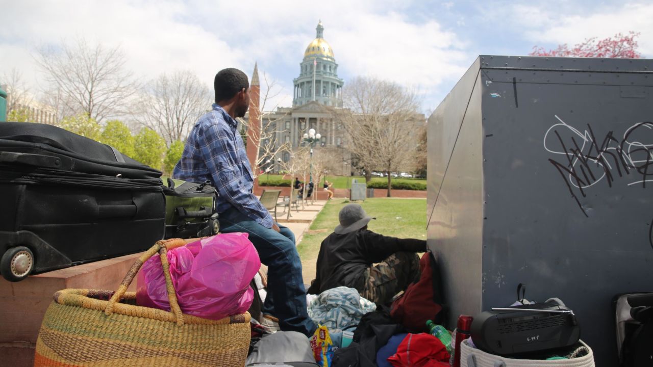 Homeless men look toward the Colorado state capitol in Civic Center Park, Denver. The rate of homelessness in Colorado has risen in recent years, despite falling national numbers.