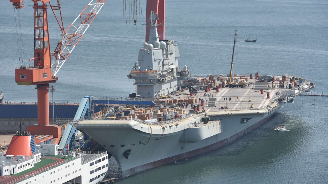 Chinese workers labor on the deck of China's first domestically built aircraft carrier, the Type 001A, at the shipyard in Dalian on 16 April.