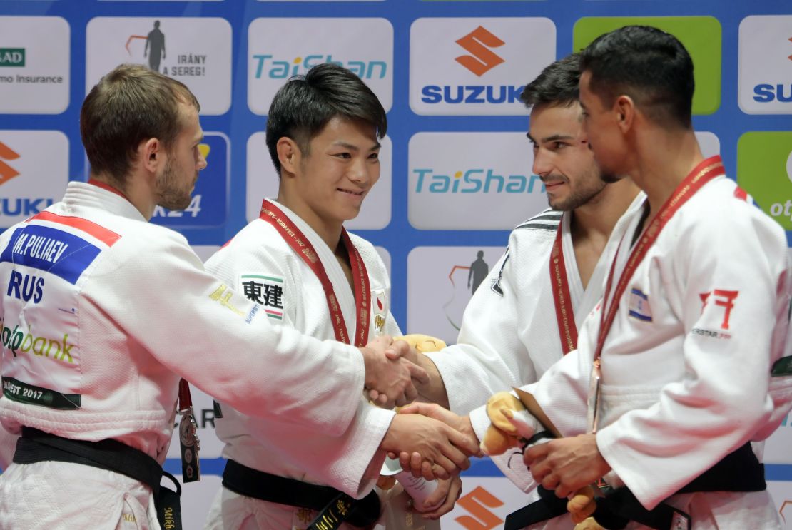 Flicker embraces fellow medalists Mikhail Puliaev (L), Hifumi Abe and Cazha Margvelashvili at the 2017 World Championships.
