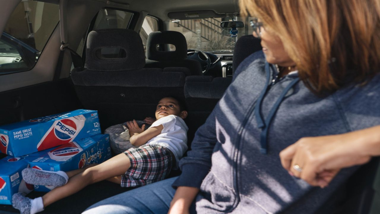 Lisbeth Cruz, right, has been looking for a place to rent but hasn't been able to find anything affordable. She watches out for her neighbor's child at the Super 8.