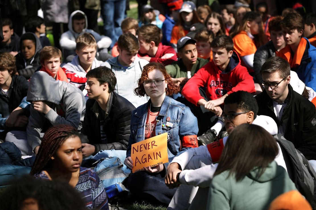 Washington area students observe moments of silence Friday while rallying in front of the White House.