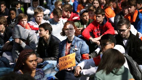 Washington area students observe moments of silence Friday while rallying in front of the White House.