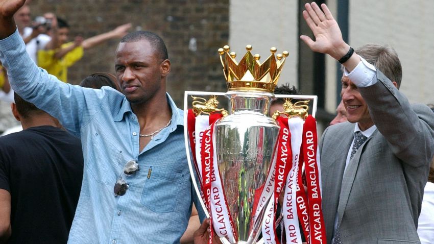 LONDON, UNITED KINGDOM: Arsenal team captain Patrick Vieira (L) and manager Arsene Wenger wave from the open-top bus carrying the winners of the British Premier League Championship, Arsenal players and their families, on its way to Islington Town Hall,16 May 2004, as part of the Club's victory celebration. AFP PHOTO/ Martyn HAYHOW (Photo credit should read MARTYN HAYHOW/AFP/Getty Images)