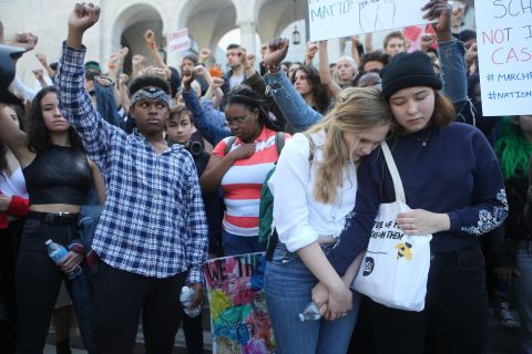 Students embrace as others raise their fists in a moment of silence for victims in Los Angeles.