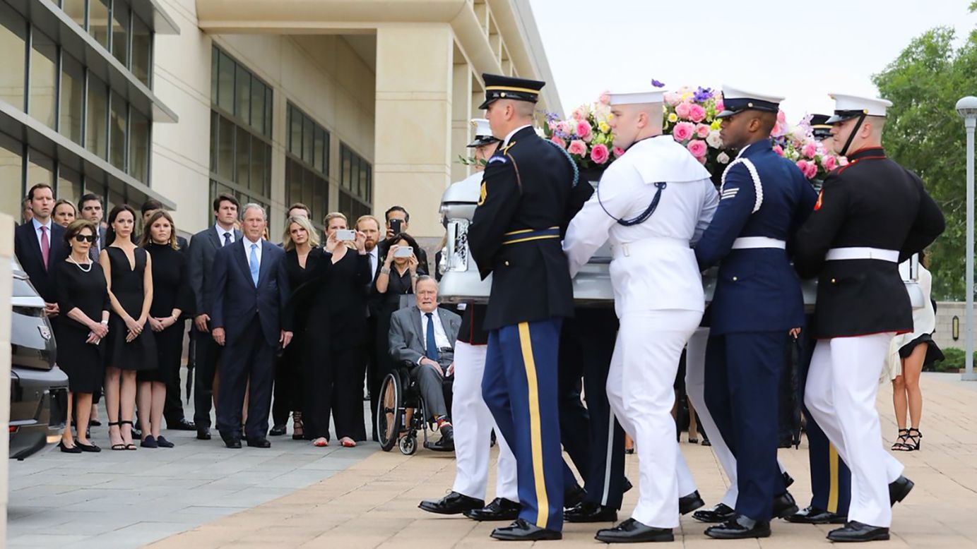 The casket of the late first lady Barbara Bush passes as members of her family, including former presidents George W. Bush and George H.W. Bush, look on.