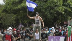 A student waves the Nicaraguan national flag over a barricade close Nicaragua's Technical College during a protest against government's reforms in the Institute of Social Security (INSS) in Managua on April 21, 2018. - A protester and a policeman were killed in the Nicaraguan capital Managua after demonstrations over pension reform turned violent Thursday night, officials said. The deaths came after protests by both opponents and supporters of a new law, which increases employer and employee contributions while reducing the overall amount of pensions by five percent, rocked the capital for a second day. (Photo by INTI OCON / AFP)        (Photo credit should read INTI OCON/AFP/Getty Images)