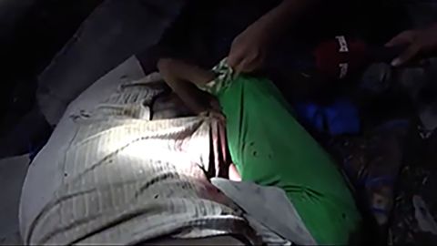 A young boy clings to his unconscious father's body after the airstrikes.