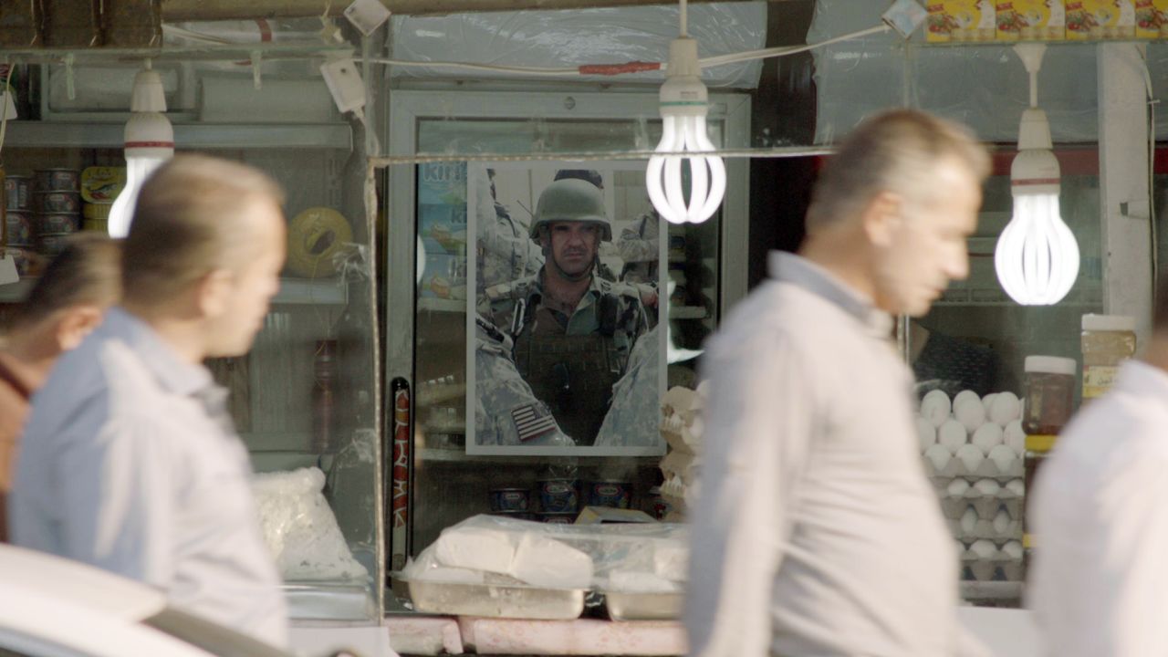 A portrait of Fakhir Berwari hangs behind a shop counter in Duhok, Iraq.