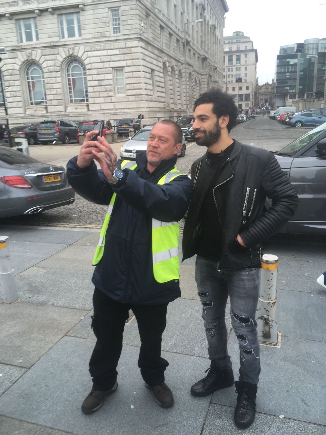Salah pauses for a selfie with a fan while walking by the River Mersey.