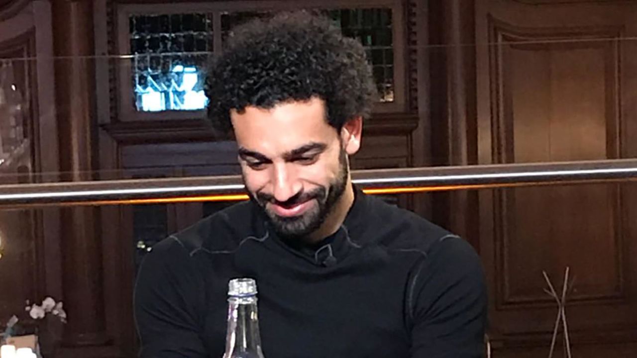 Salah watches a video message from his first coach back in Egypt while waiting for dinner.