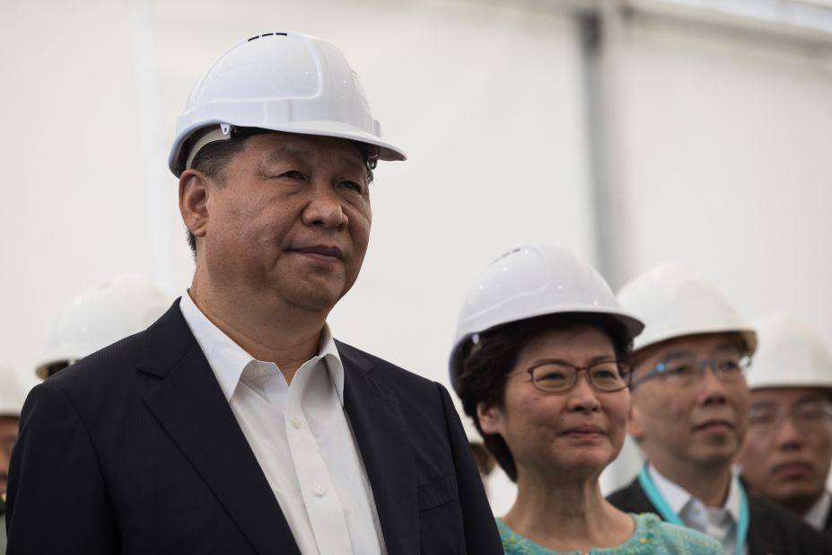 China's President Xi Jinping (left) and Hong Kong's chief executive Carrie Lam (center) in Hong Kong, watching a presentation during a visit to the Hong Kong-Zhuhai-Macau bridge on July 1, 2017. 