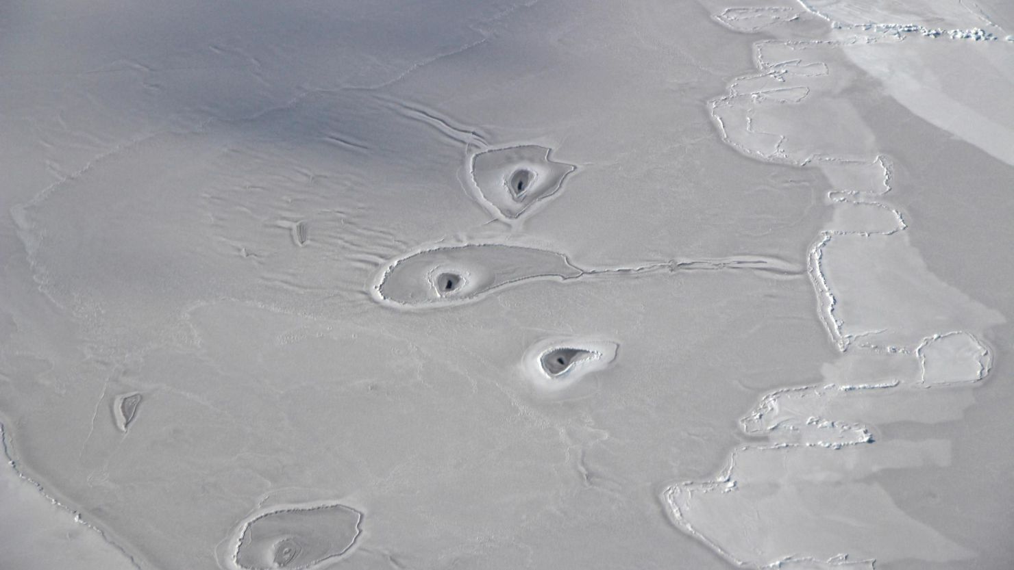 This NASA image shows unexplained holes in the surface of some ice in the Beaufort Sea.