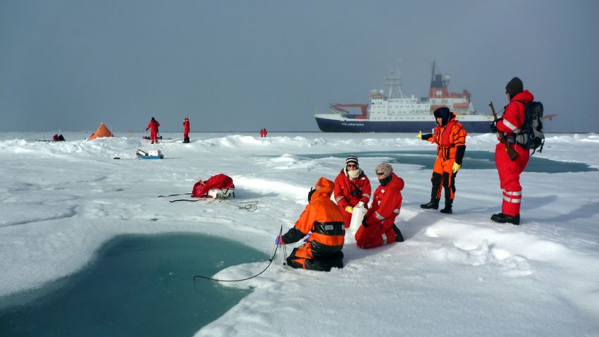 Researchers at melt pond on arctic sea ice
