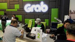 Employees attend to customers in the GrabCar division of Grab's office in Midview City in Singapore, on Wednesday, Oct. 19, 2016. Grab is riding a Southeast Asian ride-hailing arena with some 620 million people, forecast to grow more than five times to $13 billion by 2025. Photographer: Ore Huiying/Bloomberg via Getty Images