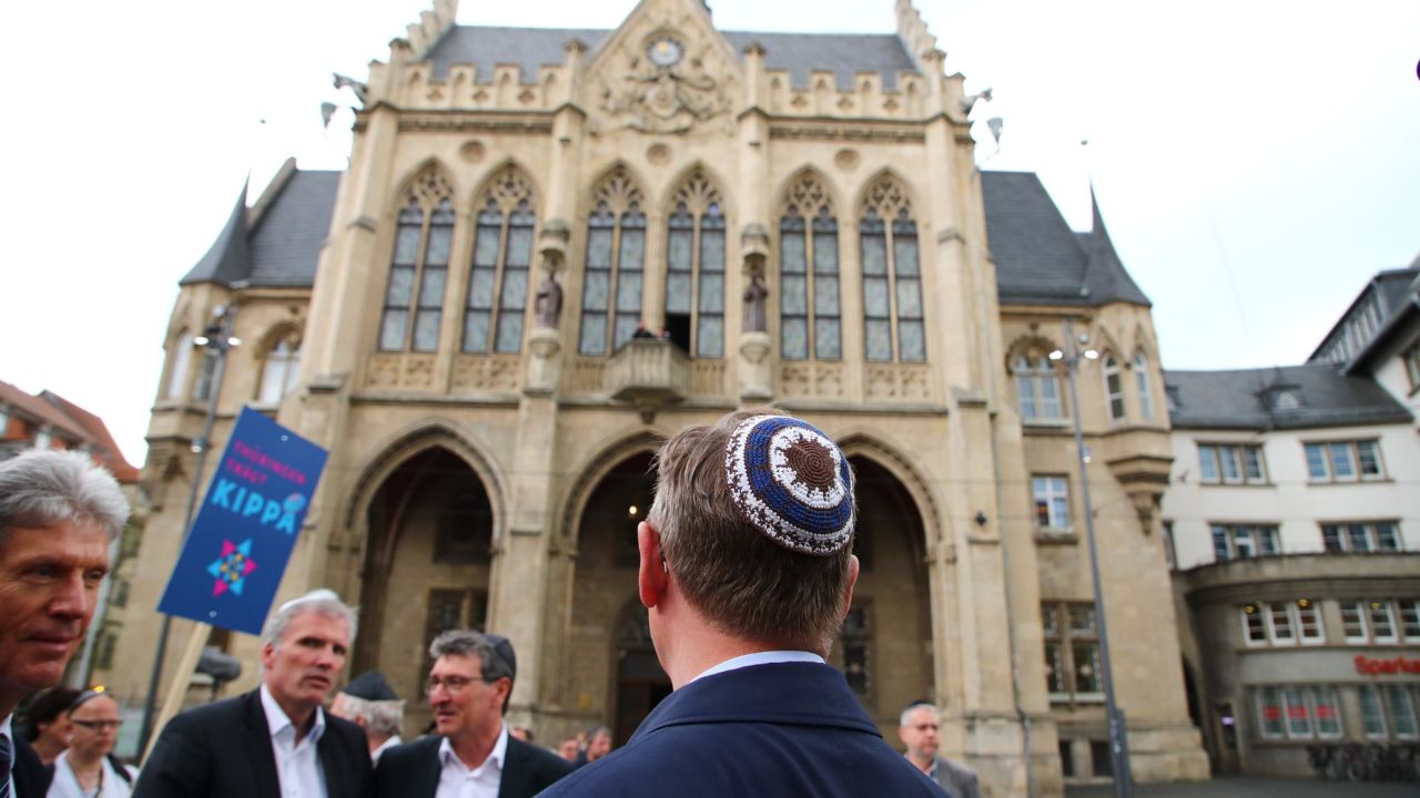 Thuringia's State Premier Bodo Ramelow (C) wears a kippa during a rally in Erfurt.
