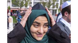 Muslim woman Iman Jamous fixes the Jewish kippah on her head during a demonstration against antisemitism in Germany in Erfurt, Germany, Wednesday, April 25, 2018. (AP Photo/Jens Meyer)