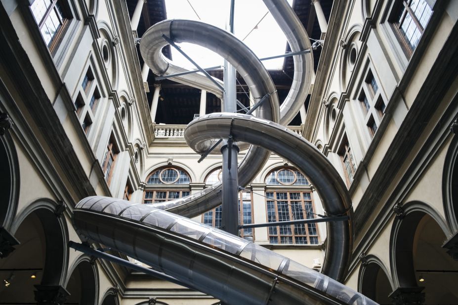 In Florence's historic Palazzo Strozzi, artist Carsten Höller asks visitors to hold a plant while going down a slide to explore the impact of human emotion on plant growth.