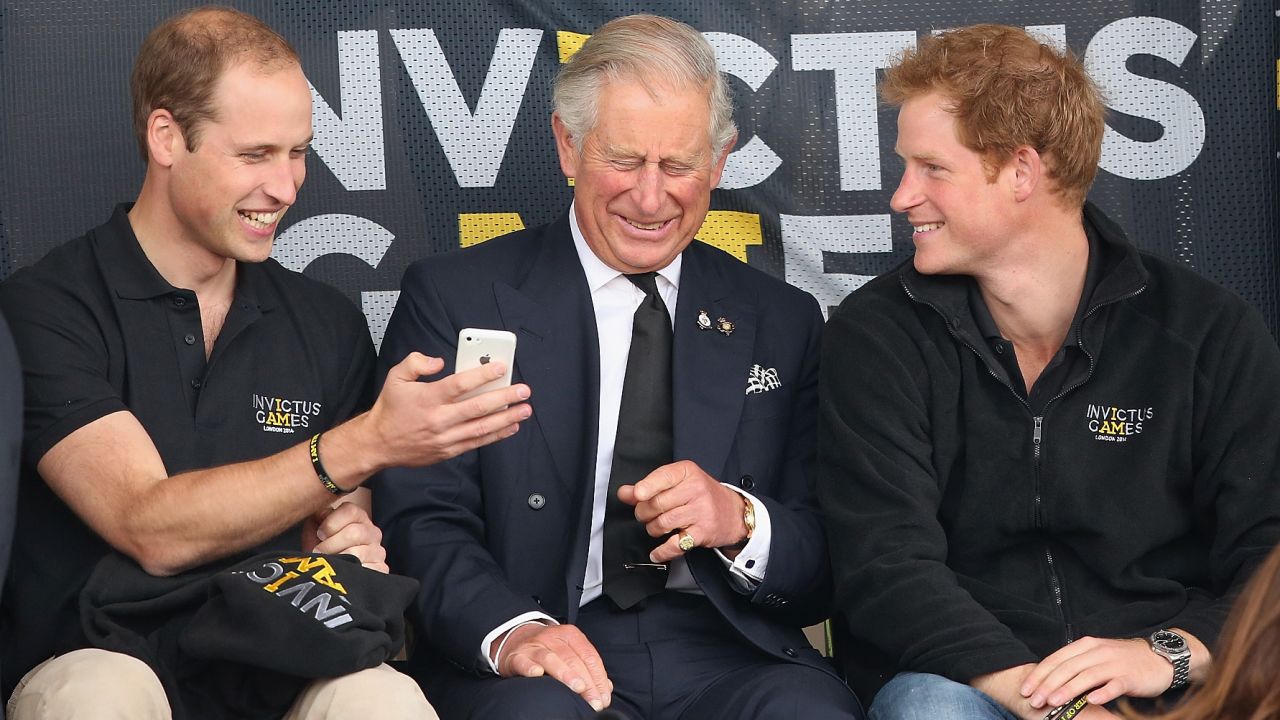 Harry and his older brother William share a joke with their father Charles during the Invictus Games in 2014. London, UK, September 2014. 