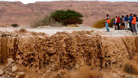 A crowd watches as floodwaters rush through a valley Thursday in the Judean Desert.
