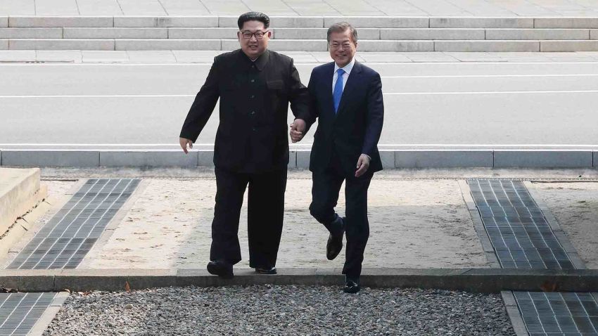 TOPSHOT - North Korea's leader Kim Jong Un (L) steps with South Korea's President Moon Jae-in (R) across the Military Demarcation Line that divides their countries ahead of their meeting at the official summit Peace House building at Panmunjom on April 27, 2018. - North Korean leader Kim Jong Un and the South's President Moon Jae-in sat down to a historic summit Friday after shaking hands over the Military Demarcation Line that divides their countries in a gesture laden with symbolism. (Photo by Korea Summit Press Pool / Korea Summit Press Pool / AFP)        (Photo credit should read KOREA SUMMIT PRESS POOL/AFP/Getty Images)