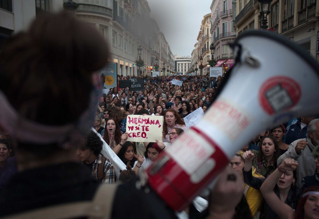 A woman holds a placard reading, "Sister, I believe you," as large crowds demonstrate in Málaga.