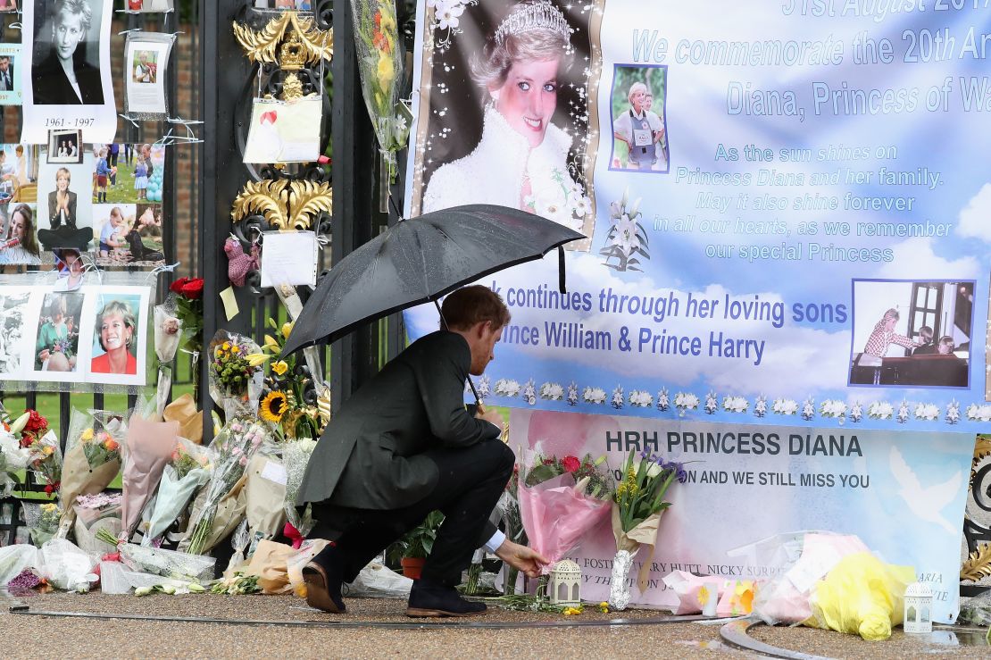 Prince Harry looks at flowers, photos and other souvenirs left as a tribute to Diana near the Sunken Garden at Kensington Palace in August 2017.