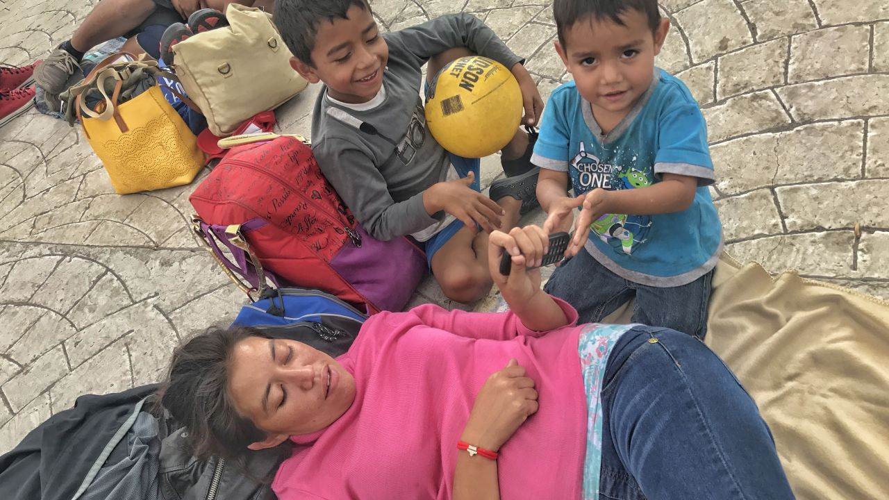 Gabriela Hernandez, exhausted by the journey, lay down when she arrived in a plaza in Tutitlán, Mexico. She says her whole family became sick while traveling with the caravan.