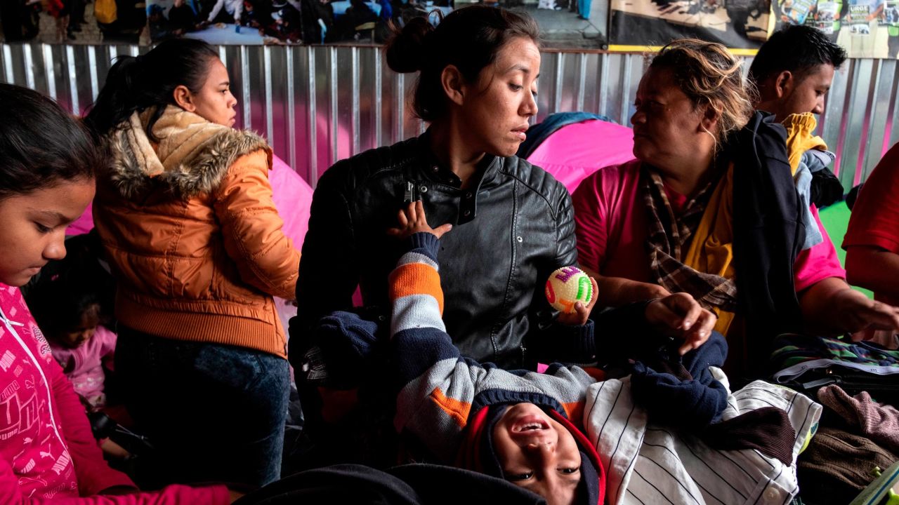 Gabriela Hernandez and her son Jhonnathan, Central American migrants traveling in the "Migrant Via Crucis" caravan pick up clothing at Juventud 2000 shelter   in Tijuana, Baja California state, Mexico, on April 27, 2018. 