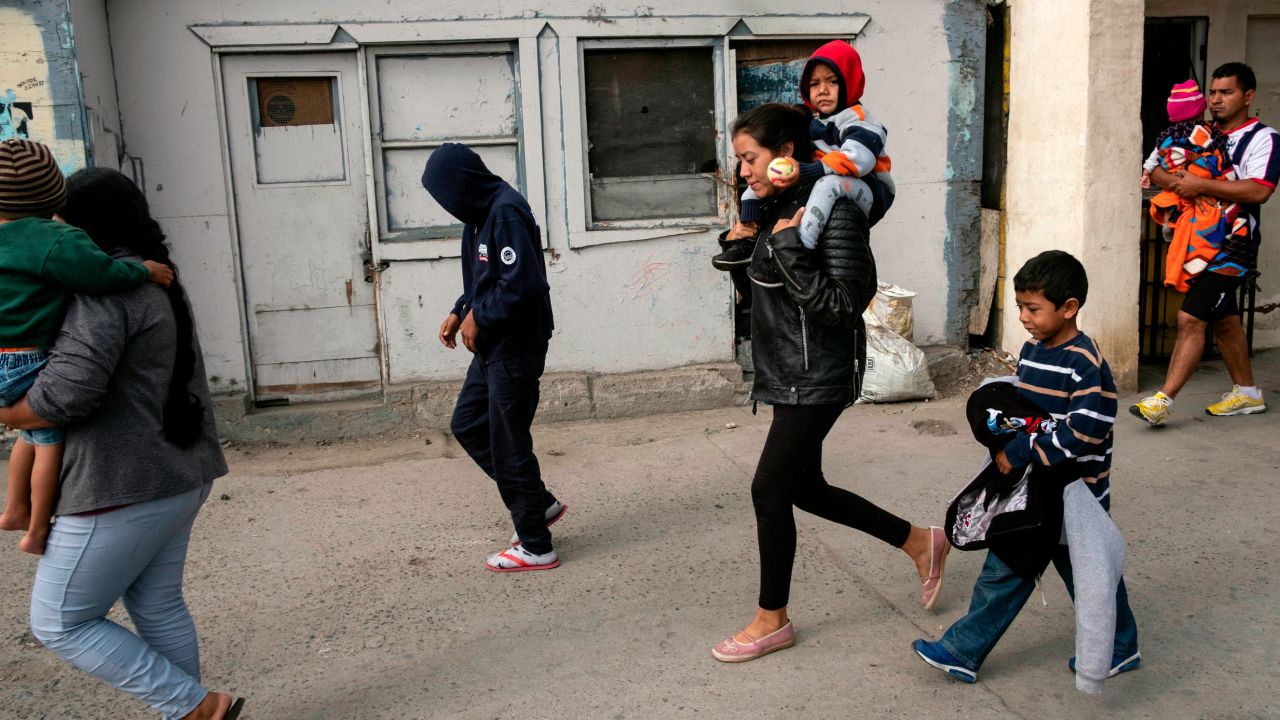 Gabriela Hernandez carries Jonathan with Omar next to her in Tijuana, before she surrendered to US officials.