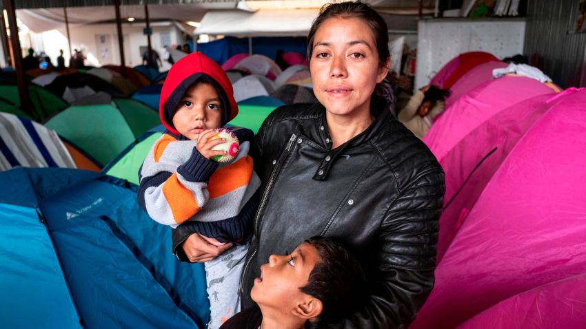 Gabriela Hernandez and her children Jhonnathan and Omar, Central American migrants traveling in the "Migrant Via Crucis" caravan stand for a portrait outside near their tent at Juventud 2000 shelter   in Tijuana, Baja California state, Mexico, on April 27, 2018.