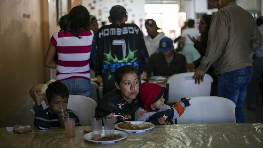 Gabriela Hernandez and her son Jhonnathan, Central American migrants traveling in the "Migrant Via Crucis" caravan have breakfast at  Padre Chava's kitchen soup where caravan members breakfast and meet US lawyers for counsel  in Tijuana, Baja California state, Mexico, on April 27, 2018.