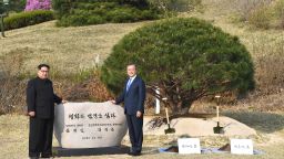 North Korea's leader Kim Jong Un (L) and South Korea's President Moon Jae-in (R) pose in front of a stone inscribed "Peace and Prosperity Are Planted" as they participate in a tree-planting ceremony next to the Military Demarcation Line that forms the border between the two Koreas at the truce village of Panmunjom on April 27, 2018. - North Korean leader Kim Jong Un and the South's President Moon Jae-in sat down to a historic summit on April 27 after shaking hands over the Military Demarcation Line that divides their countries in a gesture laden with symbolism. (Photo by Korea Summit Press Pool / Korea Summit Press Pool / AFP)        (Photo credit should read KOREA SUMMIT PRESS POOL/AFP/Getty Images)