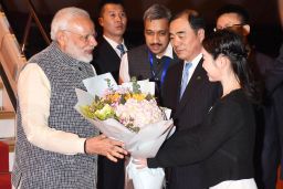 Indian Prime Minister Narendra Modi (L) receives a bunch of flowers after arriving in Wuhan in China's central Hubei province on April 27, 2018. 