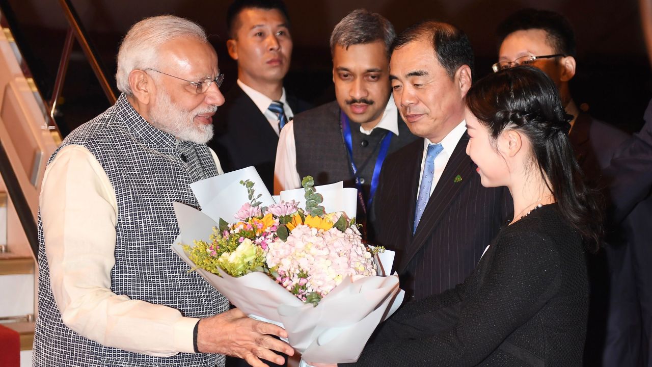 Indian Prime Minister Narendra Modi, left, receives a bunch of flowers after arriving in Wuhan in China's central Hubei province on April 27, 2018.