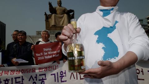 A pro-unification activist in Seoul holds a bottle of ginseng wine from the North Korean city of Kaesong on Friday.