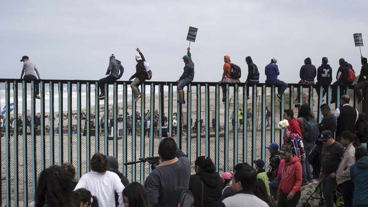 Central American migrants traveling with a caravan gather at the border wall, some sitting on top of it, look toward the U.S. from Mexico during a gathering of migrants living on both sides of the border, on the beach where the border wall ends in the ocean, in Tijuana, Mexico, Sunday, April 29, 2018. U.S. immigration lawyers are telling Central Americans in a caravan of asylum-seekers that traveled through Mexico to the border with San Diego that they face possible separation from their children and detention for many months. They say they want to prepare them for the worst possible outcome. (AP Photo/Hans-Maximo Musielik)