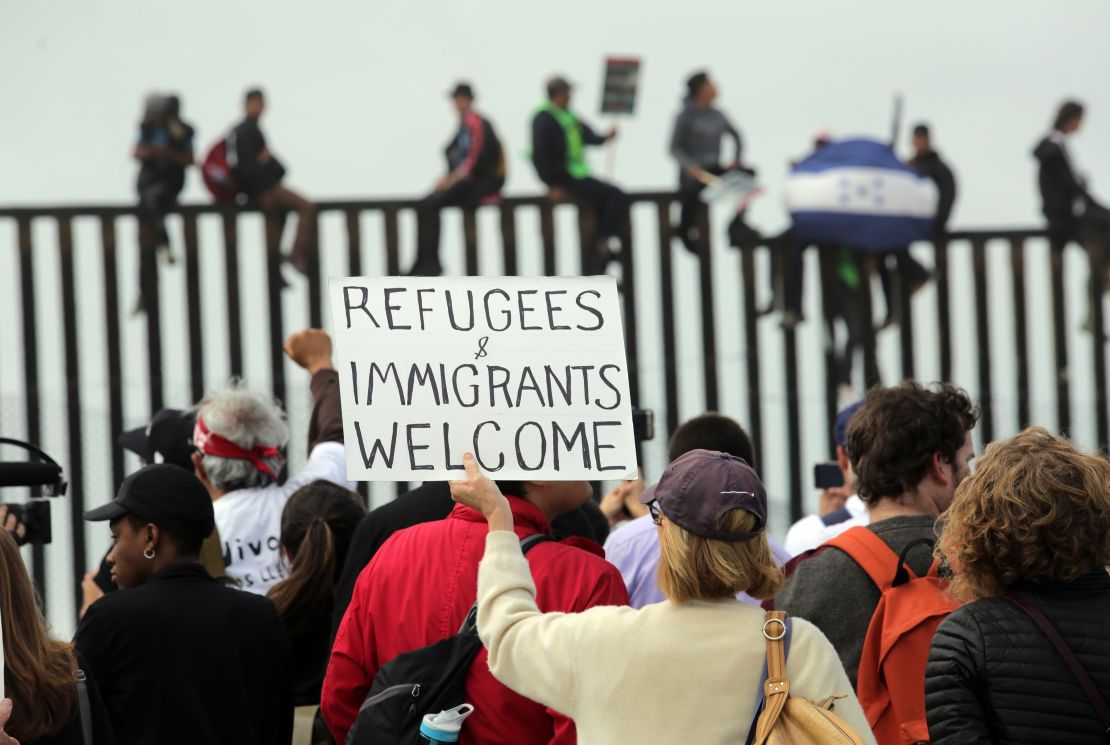 Pro-migrant caravan demonstrators rally at the US-Mexico border on April 29 in San Diego.