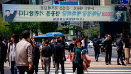 Seoul, SOUTH KOREA - APRIL 27: People walk under the placard celebrating Inter-Korean Summit in the street on April 27, 2018 in Seoul, South Korea. North Korean leader Kim Jong Un and South Korean President Moon Jae-in meets at the border today for the third-ever inter-Korean summit talks since the 1945 division of the peninsula. (Photo by Woohae Cho/Getty Images)