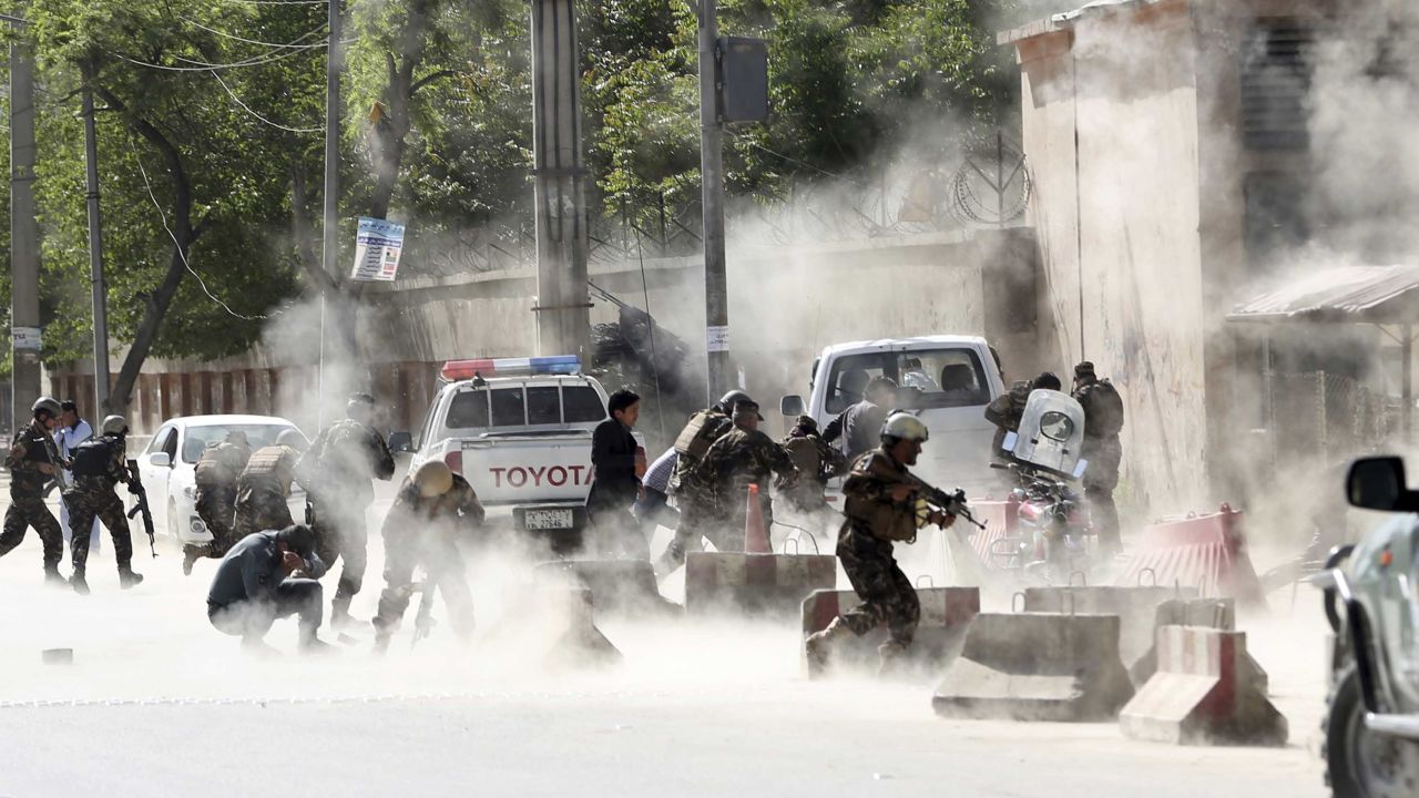 Security forces run from the site of a suicide attack after the second bombing in Kabul, Afghanistan, Monday, April 30, 2018. A coordinated double suicide bombing hit central Kabul on Monday morning, (AP Photo/Massoud Hossaini)