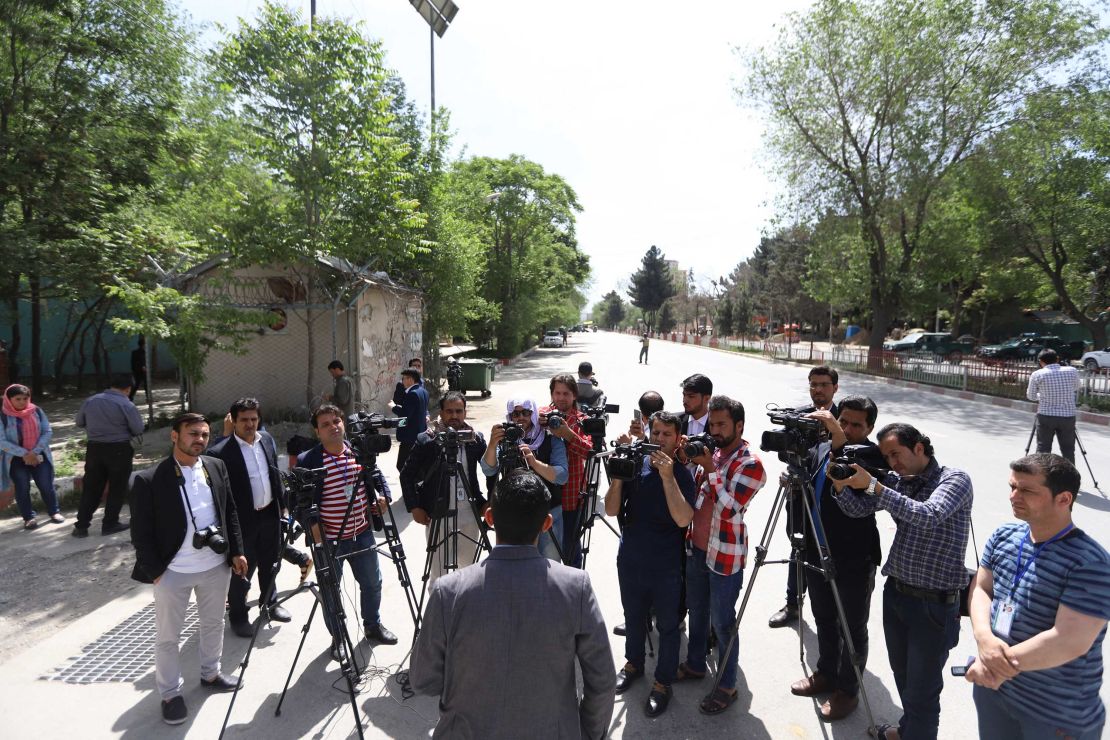 An official briefs journalists at the scene of the blasts in Kabul on Monday.